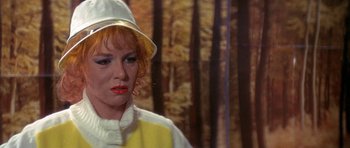 Movie still from “The Man Who Fell to Earth” (1976), directed by Nicolas Roeg – A person wearing a hat with trees in the background; Close Up shot, Over the shoulder angle