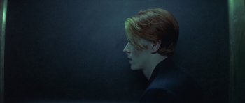 Movie still from “The Man Who Fell to Earth” (1976), directed by Nicolas Roeg – A man with red hair is looking into the distance; Close Up shot, Overhead angle