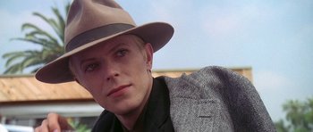 Movie still from “The Man Who Fell to Earth” (1976), directed by Nicolas Roeg – A man wearing a hat and a jacket; Close Up shot, Over the shoulder angle