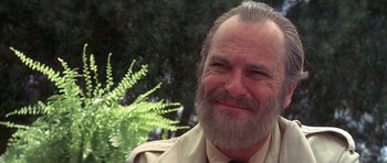 Movie still from “The Man Who Fell to Earth” (1976), directed by Nicolas Roeg – An older man with a long beard smiling for the camera; Close Up shot, Low angle