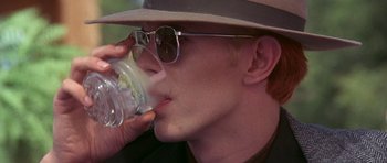 Movie still from “The Man Who Fell to Earth” (1976), directed by Nicolas Roeg – A man drinking a glass of water from a cup; Close Up shot, High angle