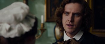 Movie still from “The Man Who Invented Christmas” (2017), directed by Bharat Nalluri – A person wearing a suit and tie; Close Up shot, Over the shoulder angle