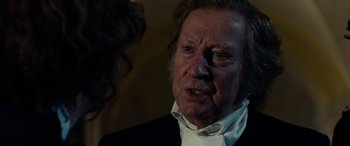 Movie still from “The Man Who Invented Christmas” (2017), directed by Bharat Nalluri – An older man in a suit and white shirt; Close Up shot, Over the shoulder angle