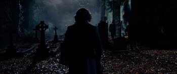 Movie still from “The Man Who Invented Christmas” (2017), directed by Bharat Nalluri – A woman walking through a graveyard at night; Wide shot, Over the shoulder angle