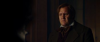 Movie still from “The Man Who Invented Christmas” (2017), directed by Bharat Nalluri – A person wearing a suit and tie; Close Up shot, Low angle