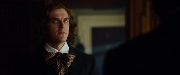 Movie still from “The Man Who Invented Christmas” (2017), directed by Bharat Nalluri – A person wearing a suit and tie; Close Up shot, Over the shoulder angle