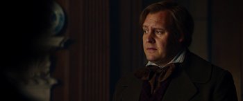 Movie still from “The Man Who Invented Christmas” (2017), directed by Bharat Nalluri – A person wearing a suit and tie; Close Up shot, Low angle