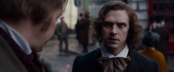 Movie still from “The Man Who Invented Christmas” (2017), directed by Bharat Nalluri – A man in a suit and tie talking to another man in a suit and tie; Close Up shot, Over the shoulder angle