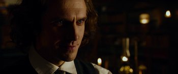 Movie still from “The Man Who Invented Christmas” (2017), directed by Bharat Nalluri – A person wearing a suit and tie; Close Up shot, Over the shoulder angle