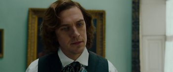 Movie still from “The Man Who Invented Christmas” (2017), directed by Bharat Nalluri – A person wearing a suit and tie; Close Up shot, Over the shoulder angle