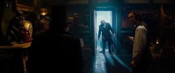 Movie still from “The Man Who Invented Christmas” (2017), directed by Bharat Nalluri – A man is walking through a doorway to a room; Wide shot, Low angle