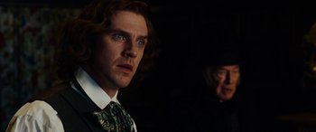 Movie still from “The Man Who Invented Christmas” (2017), directed by Bharat Nalluri – A person wearing a suit and a tie; Close Up shot, Over the shoulder angle