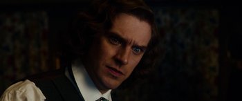 Movie still from “The Man Who Invented Christmas” (2017), directed by Bharat Nalluri – A person wearing a suit and tie; Close Up shot, Over the shoulder angle