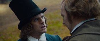 Movie still from “The Man Who Invented Christmas” (2017), directed by Bharat Nalluri – A man wearing a top hat talking to another man; Close Up shot, Over the shoulder angle