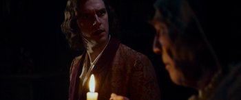 Movie still from “The Man Who Invented Christmas” (2017), directed by Bharat Nalluri – A man holding a candle in front of another man; Close Up shot, Over the shoulder angle