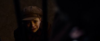 Movie still from “The Man Who Invented Christmas” (2017), directed by Bharat Nalluri – A young boy wearing a hat looking at the camera; Close Up shot, High angle