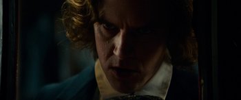 Movie still from “The Man Who Invented Christmas” (2017), directed by Bharat Nalluri – A person wearing a suit and tie; Close Up shot, Over the shoulder angle