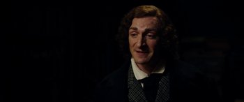 Movie still from “The Man Who Invented Christmas” (2017), directed by Bharat Nalluri – A person wearing a suit and tie; Close Up shot, Over the shoulder angle