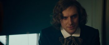 Movie still from “The Man Who Invented Christmas” (2017), directed by Bharat Nalluri – A person wearing a suit and tie; Close Up shot, Over the shoulder angle