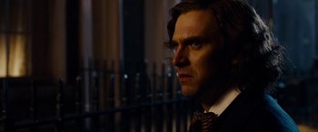 Movie still from “The Man Who Invented Christmas” (2017), directed by Bharat Nalluri – A person wearing a suit and tie; Close Up shot, Over the shoulder angle