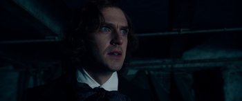 Movie still from “The Man Who Invented Christmas” (2017), directed by Bharat Nalluri – A person wearing a suit and tie; Close Up shot, Over the shoulder angle