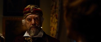 Movie still from “The Man Who Invented Christmas” (2017), directed by Bharat Nalluri – An old man with a beard wearing a hat; Close Up shot, Over the shoulder angle
