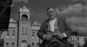 Movie still from “The Man Who Shot Liberty Valance” (1962), directed by John Ford – An older man standing in front of an old building; Medium shot, Low angle