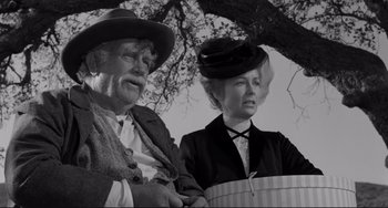 Movie still from “The Man Who Shot Liberty Valance” (1962), directed by John Ford – An older man and a younger woman standing next to each other under a tree; Medium shot, Low angle