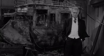 Movie still from “The Man Who Shot Liberty Valance” (1962), directed by John Ford – A black and white photo of a man in front of an old train; Medium shot, Low angle