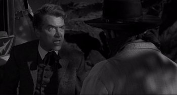 Movie still from “The Man Who Shot Liberty Valance” (1962), directed by John Ford – A man in a suit and a cowboy hat is talking to another man in a hat; Close Up shot, Over the shoulder angle