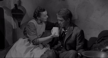 Movie still from “The Man Who Shot Liberty Valance” (1962), directed by John Ford – An old photo of a man and a woman holding a mug; Medium shot, High angle