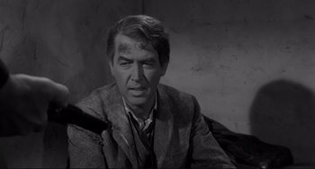 Movie still from “The Man Who Shot Liberty Valance” (1962), directed by John Ford – A black and white photo of a man in a suit; Close Up shot, Over the shoulder angle