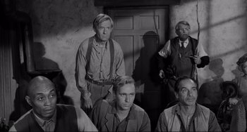 Movie still from “The Man Who Shot Liberty Valance” (1962), directed by John Ford – A black and white photo of a group of men; Medium shot, High angle