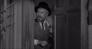 Movie still from “The Man Who Shot Liberty Valance” (1962), directed by John Ford – An old photo of an old man smoking a cigarette; Medium shot, Low angle