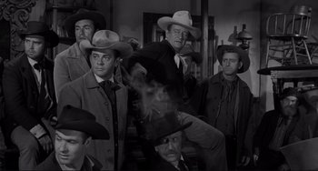 Movie still from “The Man Who Shot Liberty Valance” (1962), directed by John Ford – A group of men wearing hats and suits; Medium shot, Low angle