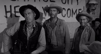 Movie still from “The Man Who Shot Liberty Valance” (1962), directed by John Ford – A black and white photo of three men wearing hats; Medium shot, Low angle