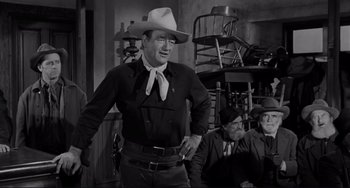 Movie still from “The Man Who Shot Liberty Valance” (1962), directed by John Ford – A black and white photo of a man wearing a cowboy hat; Medium shot, Low angle