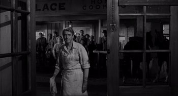 Movie still from “The Man Who Shot Liberty Valance” (1962), directed by John Ford – An older woman standing in front of a group of people; Wide shot, Low angle