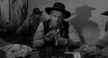 Movie still from “The Man Who Shot Liberty Valance” (1962), directed by John Ford – An old photo of a man sitting at a poker table; Close Up shot, Over the shoulder angle