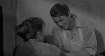 Movie still from “The Man Who Shot Liberty Valance” (1962), directed by John Ford – An old photo of a man and a woman touching hands; Medium shot, High angle