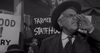 Movie still from “The Man Who Shot Liberty Valance” (1962), directed by John Ford – An older man wearing a hat and a suit; Medium shot, Low angle