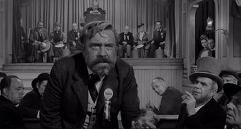 Movie still from “The Man Who Shot Liberty Valance” (1962), directed by John Ford – Black and white photograph of a man in front of a group of people; Medium shot, Low angle