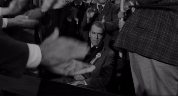 Movie still from “The Man Who Shot Liberty Valance” (1962), directed by John Ford – Black and white photograph of a man in a crowd; Medium shot, Over the shoulder angle