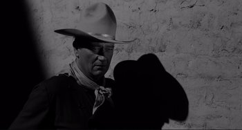 Movie still from “The Man Who Shot Liberty Valance” (1962), directed by John Ford – A man wearing a cowboy hat and a neck tie; Medium shot, Low angle