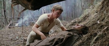 Movie still from “The Man from Snowy River” (1982), directed by George Miller – A man in a white shirt is kneeling over a dead body; Medium shot, Low angle