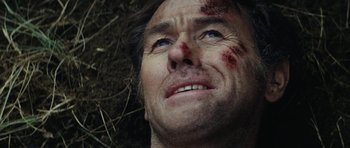 Movie still from “The Man from Snowy River” (1982), directed by George Miller – A person laying on the ground; Close Up shot, Overhead angle