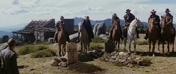 Movie still from “The Man from Snowy River” (1982), directed by George Miller – A group of men on horses in a field; Wide shot, Low angle