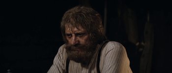 Movie still from “The Man from Snowy River” (1982), directed by George Miller – An old man with a beard and a mustache; Close Up shot, Over the shoulder angle