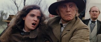 Movie still from “The Man from Snowy River” (1982), directed by George Miller – A man and a woman are standing next to each other; Close Up shot, Low angle