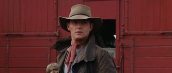 Movie still from “The Man from Snowy River” (1982), directed by George Miller – A man wearing a cowboy hat and a jacket; Close Up shot, Over the shoulder angle